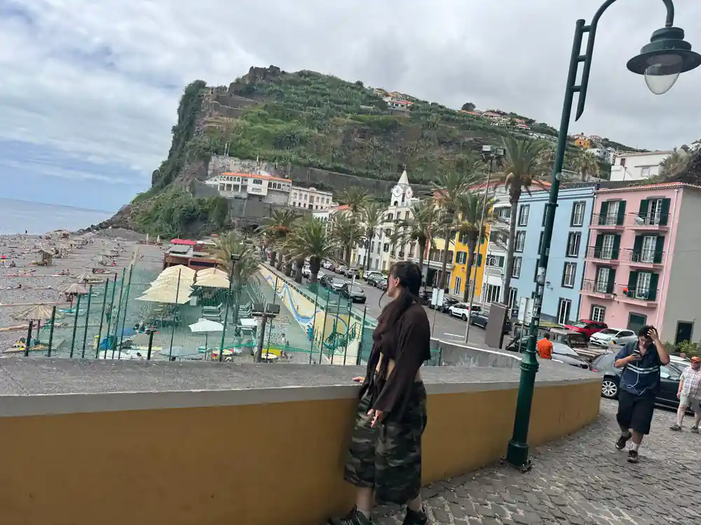 Beach cove below fortified hill with colorful buildings