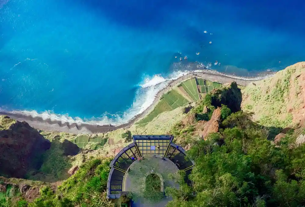 Glass platform viewpoint overlooking coastal cliffs and turquoise sea