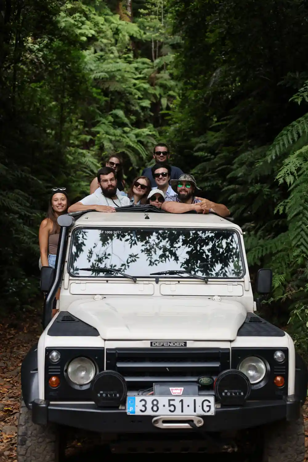 Group of people in open-top vehicle in dense green forest