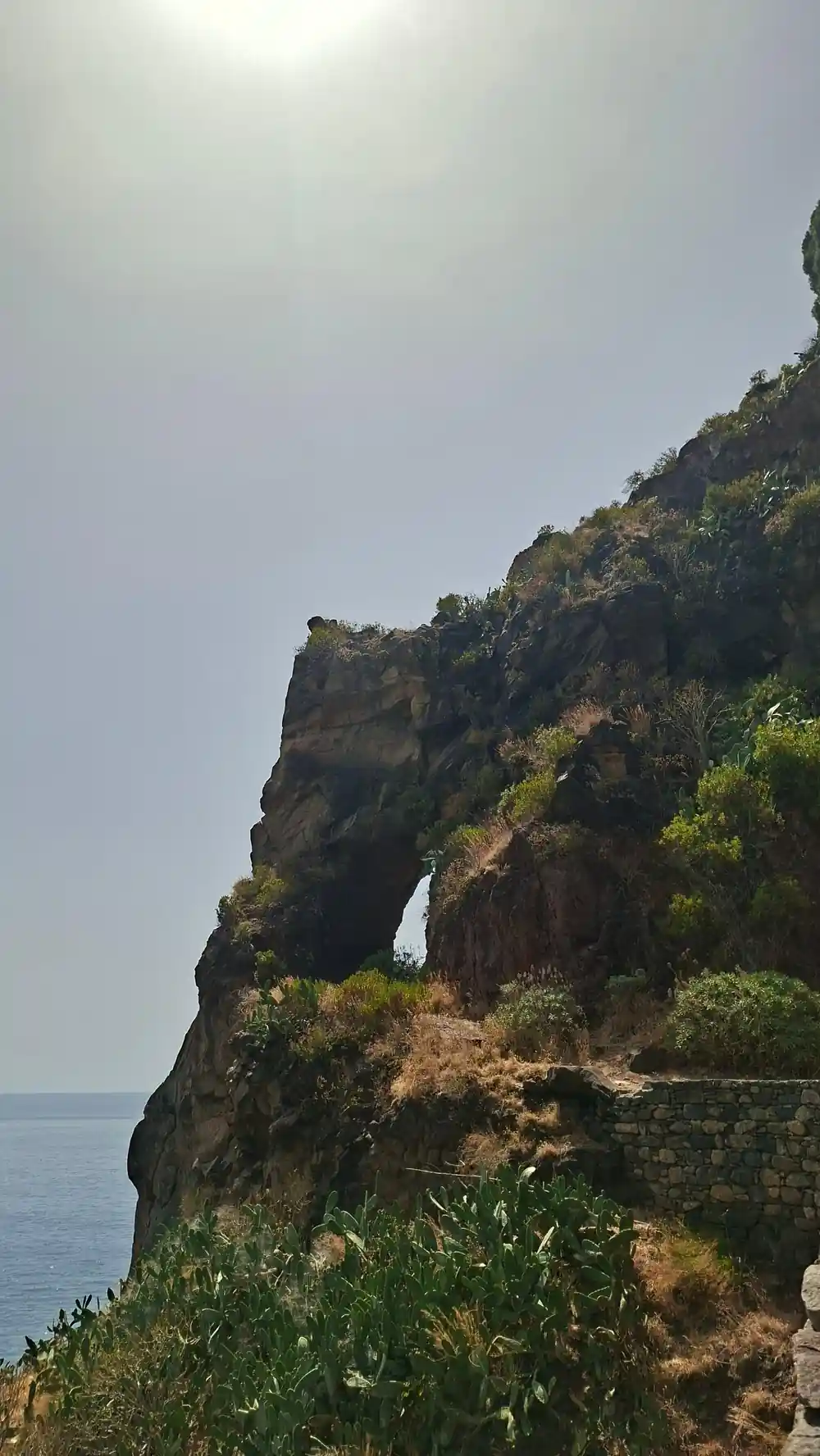Rocky coastal arch formation with ocean waves below
