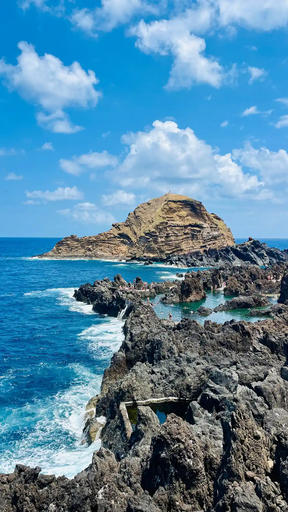 Rocky island with grassy top in blue ocean