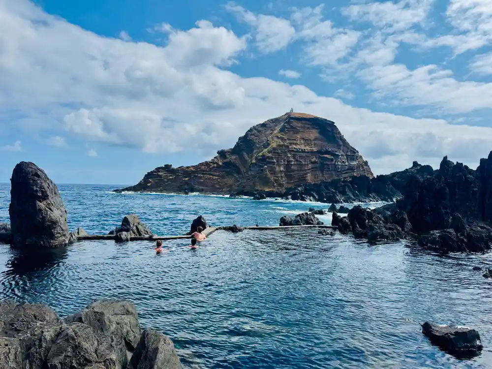 Rocky volcanic islands with swimmers in water