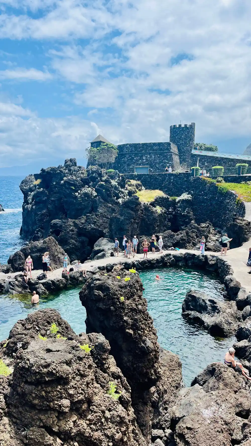 Stone castle on rocky island surrounded by turquoise water