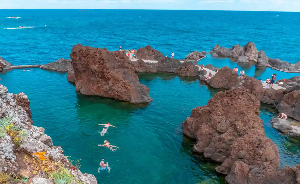 Turquoise water with brown rocky islands and formations
