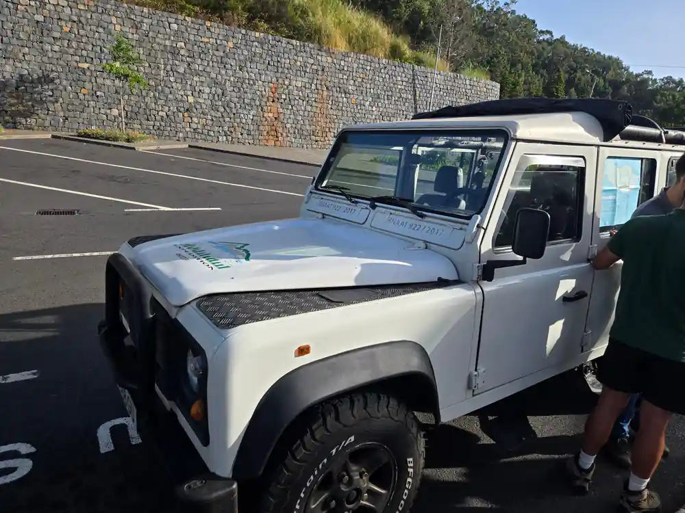 White four-wheel drive vehicle parked on mountain road